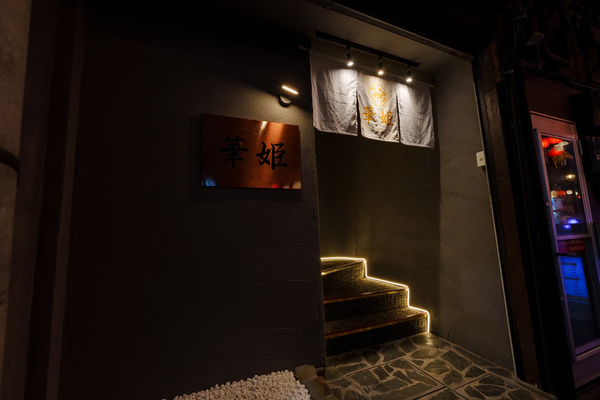 暖簾が揺れる夜の店舗ファサード